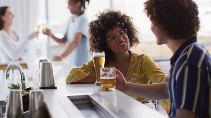 一群快乐的朋友在酒吧喝啤酒聊天