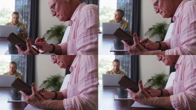 白人高年级学生在家用平板电脑做笔记