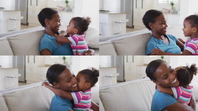 快乐的非裔美国母亲和女儿坐在沙发上拥抱