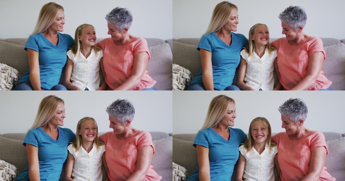 白种人的祖母，母亲和女儿坐在家里的沙发上微笑