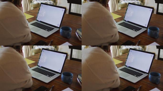 亚洲妇女坐在桌子和视频电话使用笔记本电脑与复制空间