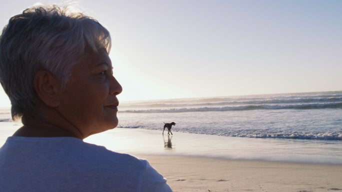 一位年长的非裔美国妇女在海滩上散步