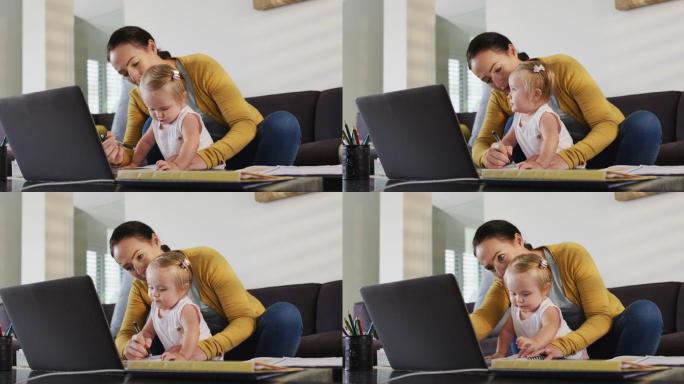 一位抱着孩子在家工作的白人母亲在做笔记