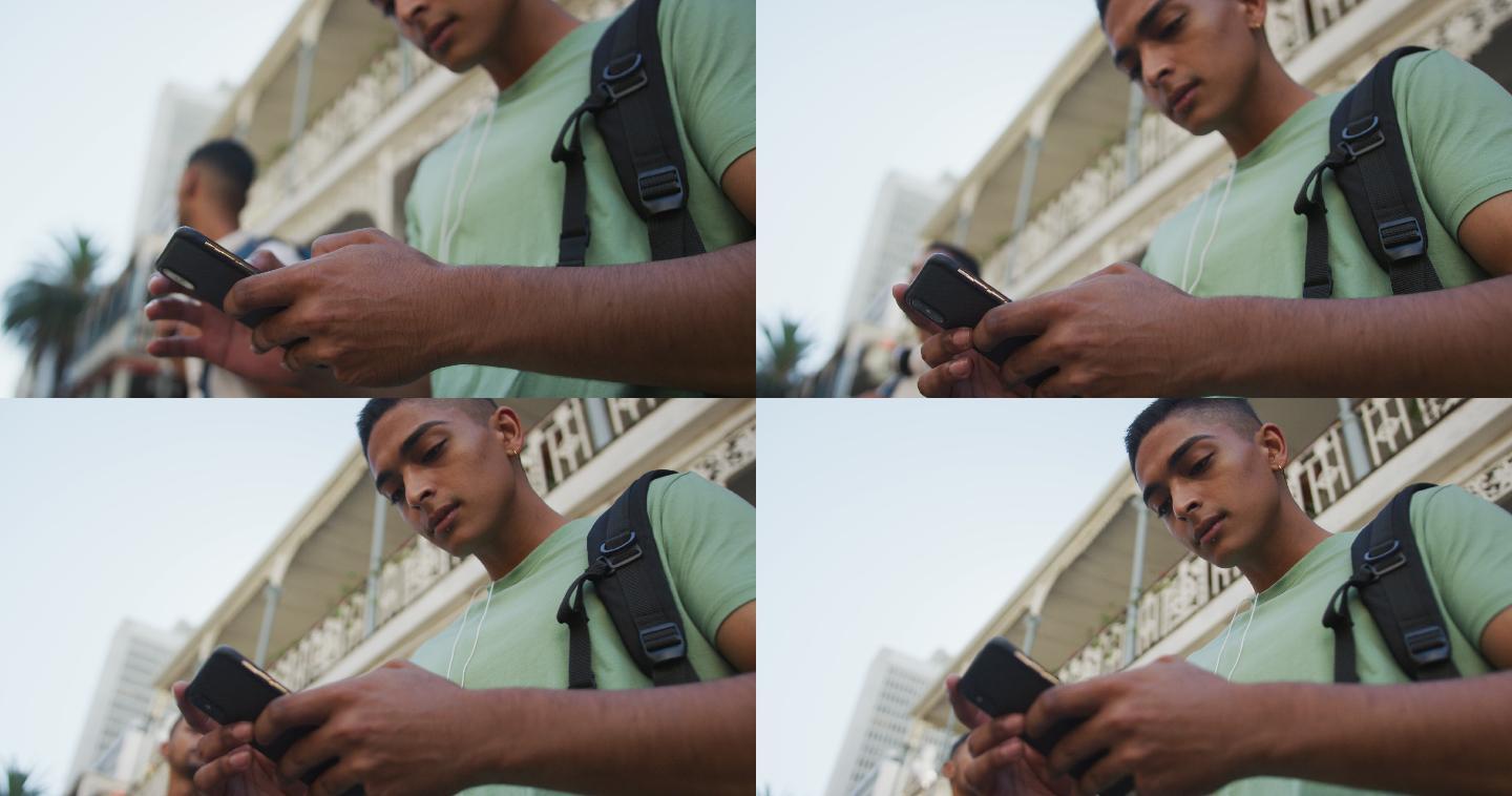混血儿男子在街上使用智能手机的特写镜头