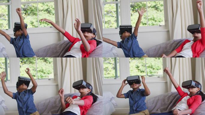 多样化的男孩和女孩坐在家里的沙发上玩戴着虚拟现实眼镜
