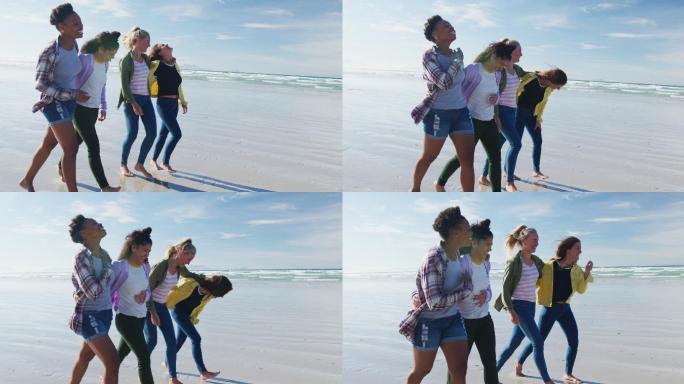 快乐的一群不同的女性朋友有乐趣，沿着海滩散步