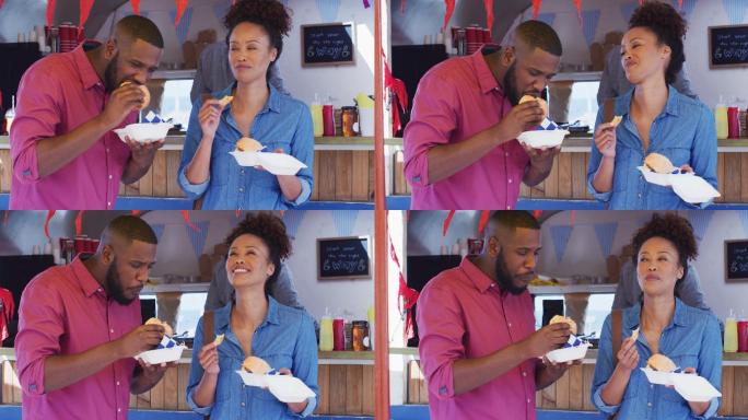 一对非裔美国夫妇在餐车上一起吃汉堡和薯条