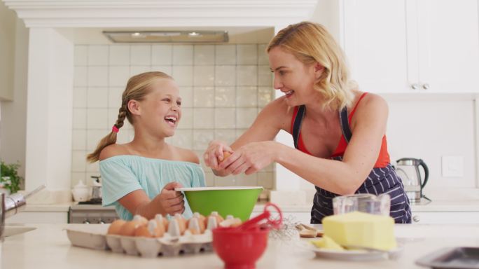 白人母亲和女儿在家的厨房里一起烘焙