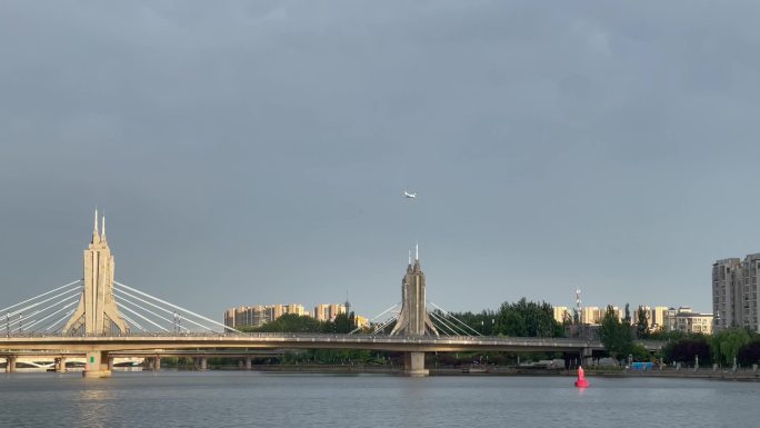 城市大桥河流楼房飞机划过天空