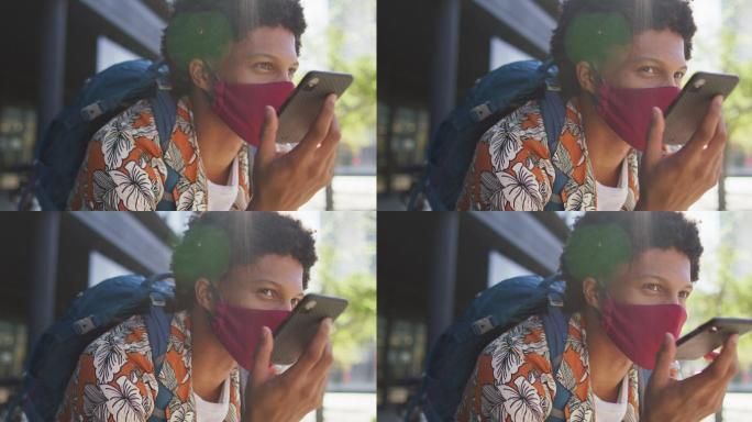 非洲裔美国人，戴着口罩坐在街上用智能手机