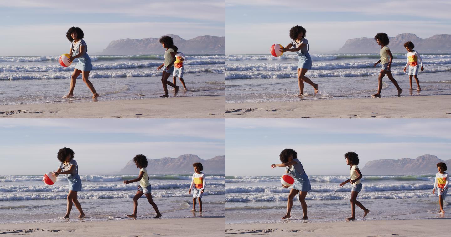 非裔美国母亲和她的孩子们在海滩上玩球