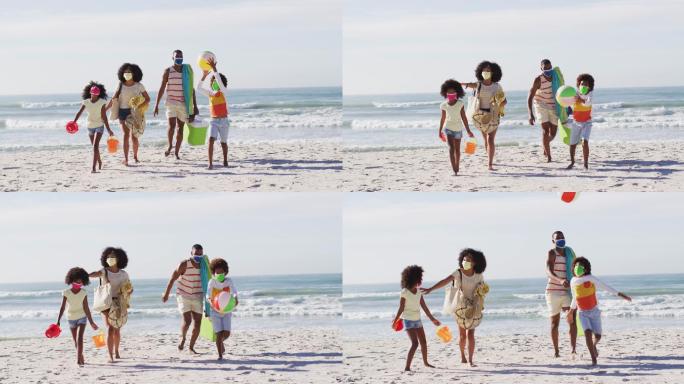 非裔美国父母和他们的孩子戴着口罩，带着海滩设备在海滩上
