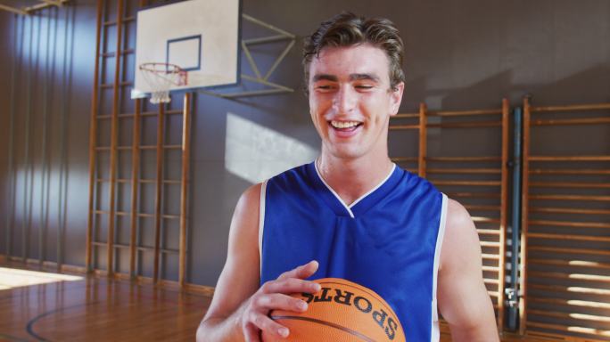 图为抱着球微笑的白人男子篮球运动员