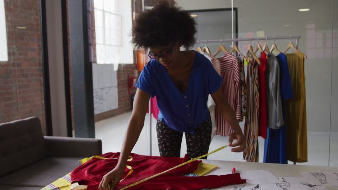 非裔美国女时装设计师用卷尺测量衣服的尺寸