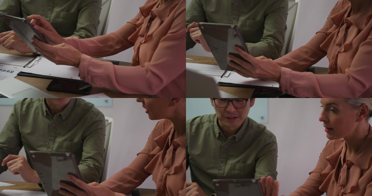 不同的男女商务同事在会议室用平板电脑讨论