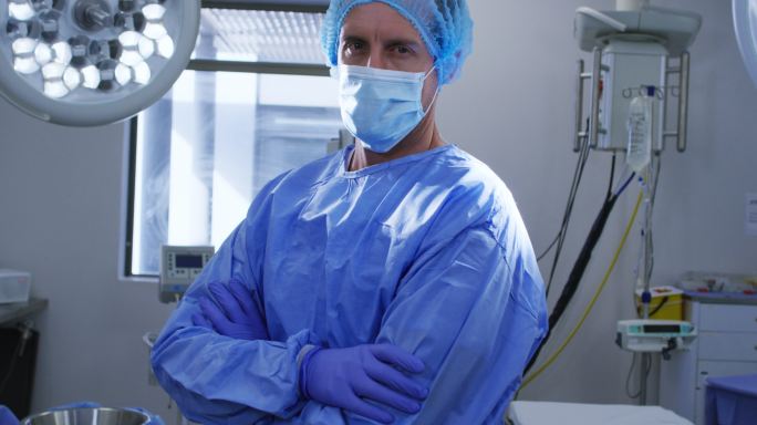 在医院里，戴着口罩、戴着手术服的男女外科医生的肖像