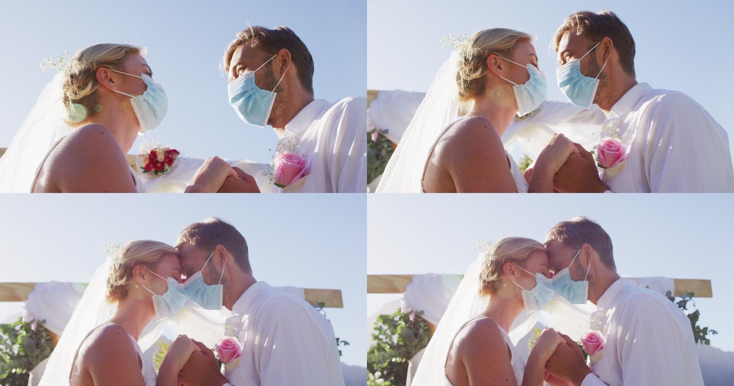幸福的白人新婚夫妇戴着面具在圣坛前触碰头的肖像