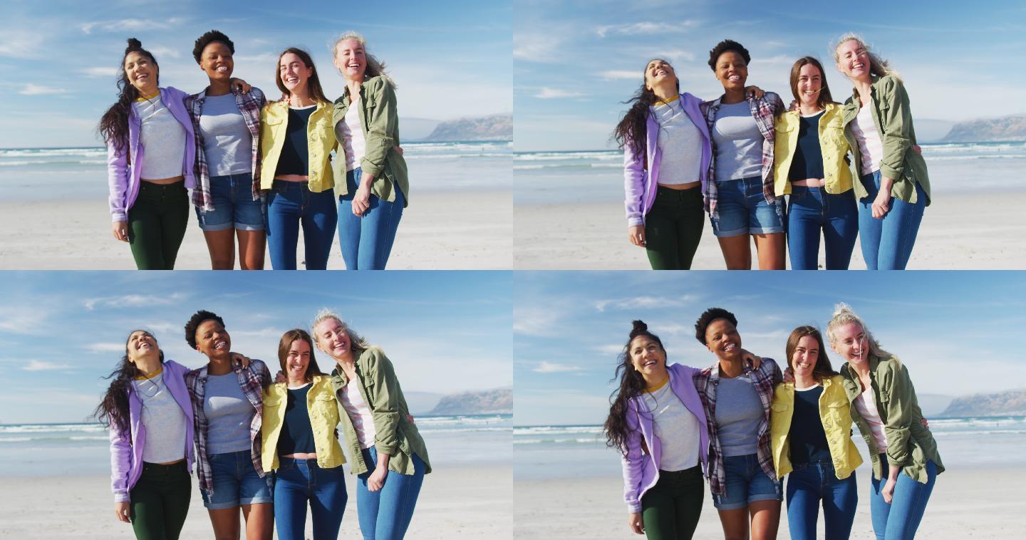快乐的一群不同的女性朋友在海滩上玩耍，大笑