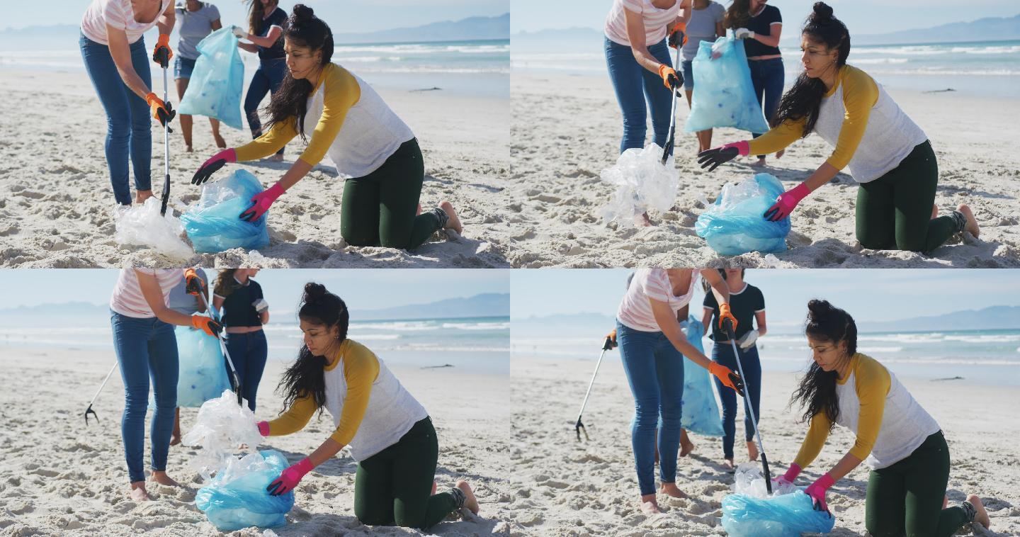 一群女性朋友在海滩上用垃圾袋扔垃圾