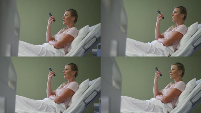 一名白人女性病人躺在医院病床上用智能手机聊天