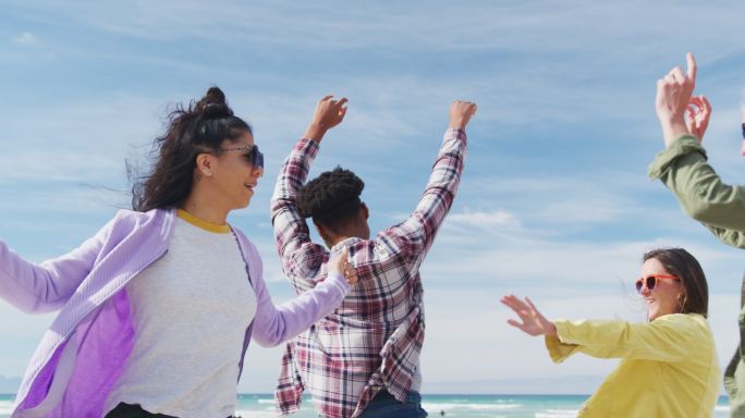 一群快乐的女性朋友在沙滩上嬉戏、跳舞、微笑