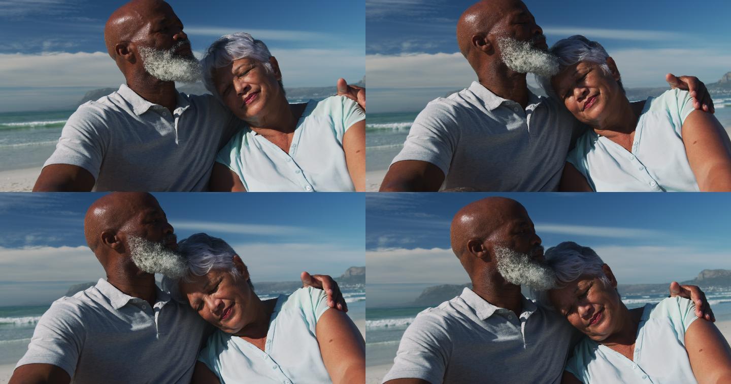 快乐的老非洲裔美国夫妇坐在沙滩上拥抱