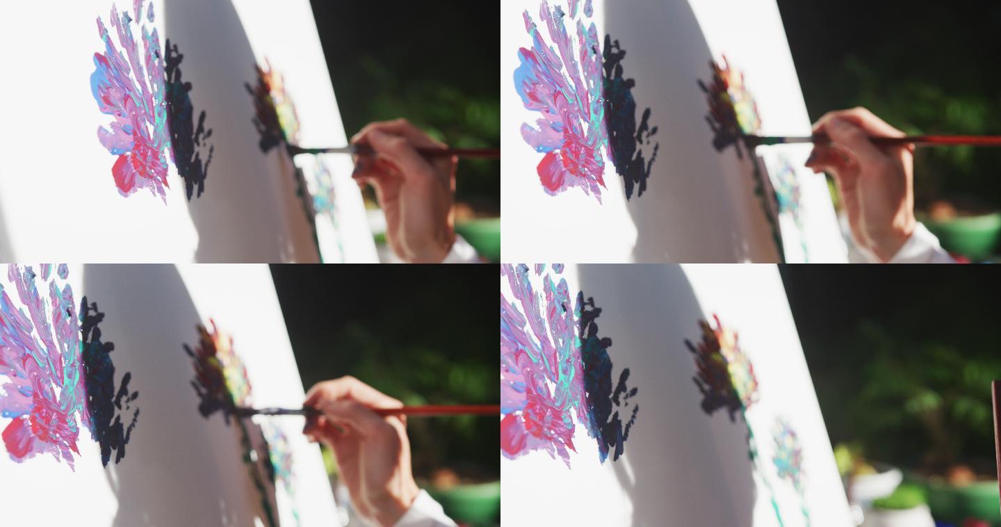白人妇女在阳光花园绘画的中段