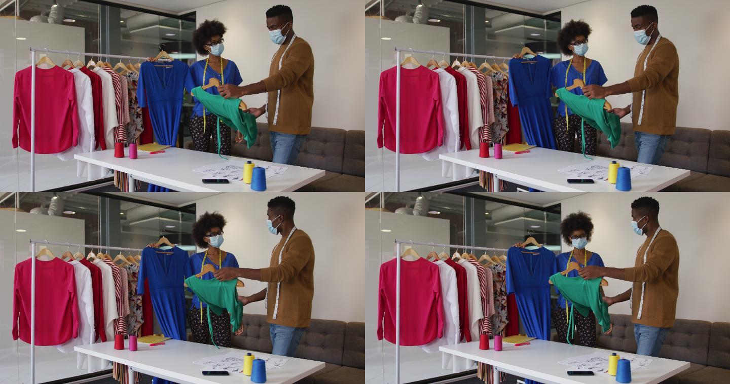 非裔美国男性和女性时装设计师戴着口罩在工作讨论