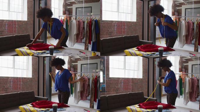 非裔美国女时装设计师用卷尺测量衣服的尺寸