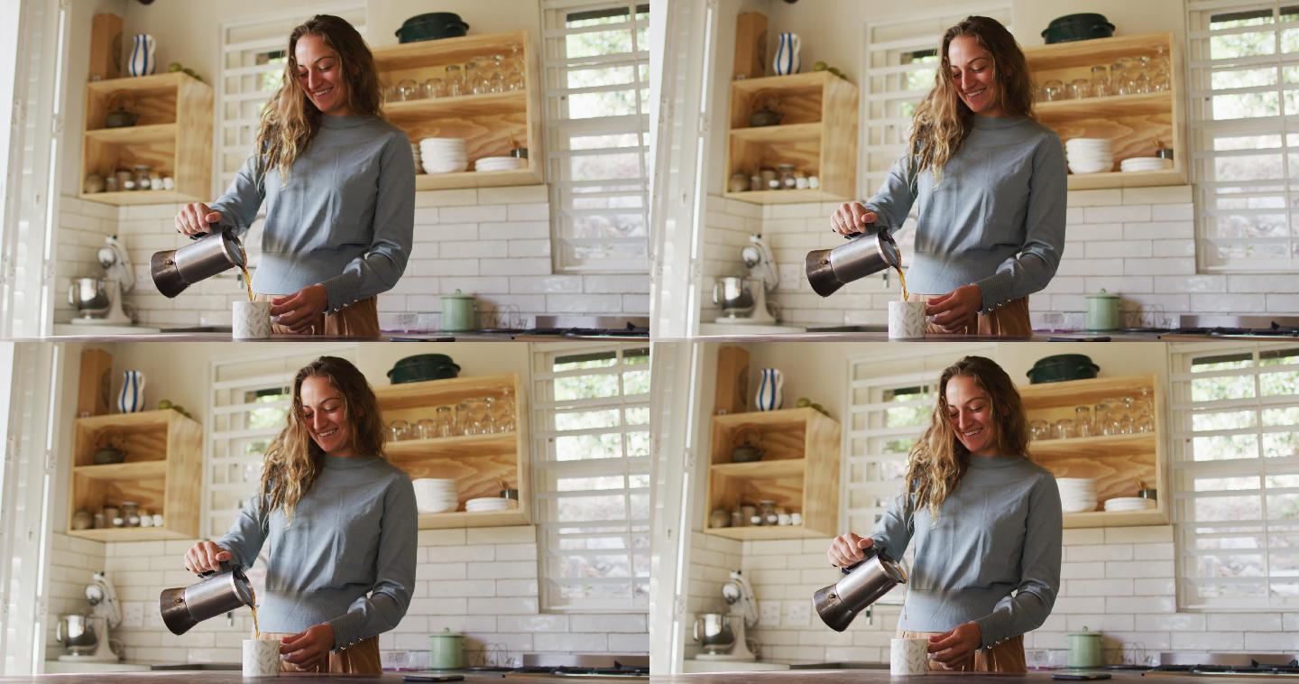 快乐的白人妇女站在村舍厨房倒咖啡从锅和微笑