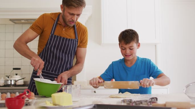 白种人的父亲和儿子一起在家里的厨房烘焙