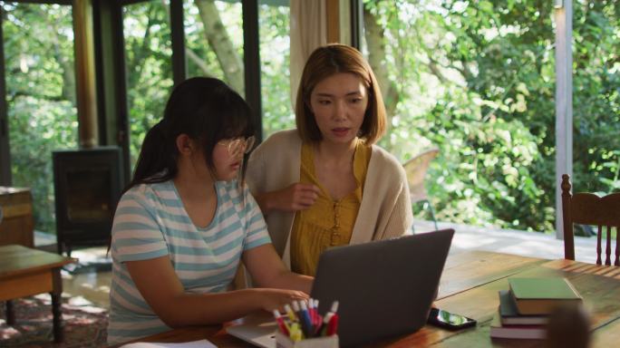亚洲母亲和女儿一起学习和使用笔记本电脑
