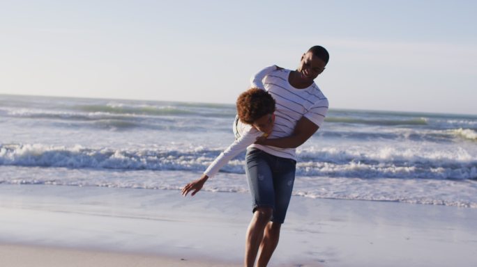 在海滩上，一对美籍黑人夫妇与他们的孩子玩耍