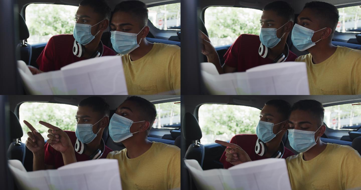 两个混血男性朋友戴着口罩在出租车上使用地图
