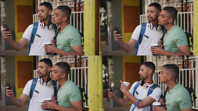 两个混血男性朋友在街上喝着咖啡，用着智能手机