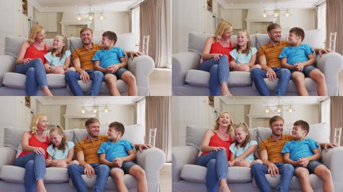 快乐的白人父母的肖像，儿子和女儿坐在家里的沙发上