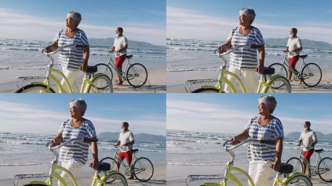 微笑的老非洲裔美国夫妇在海滩上骑自行车散步