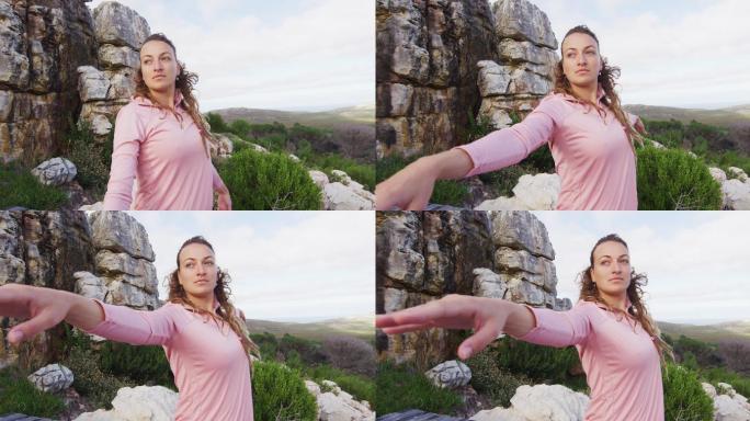白人妇女在户外练习瑜伽站在露天平台伸展在农村的山坡设置