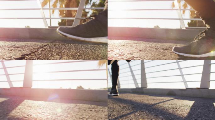 在户外运动的人的脚，在城市阳光明媚的人行桥上跑步