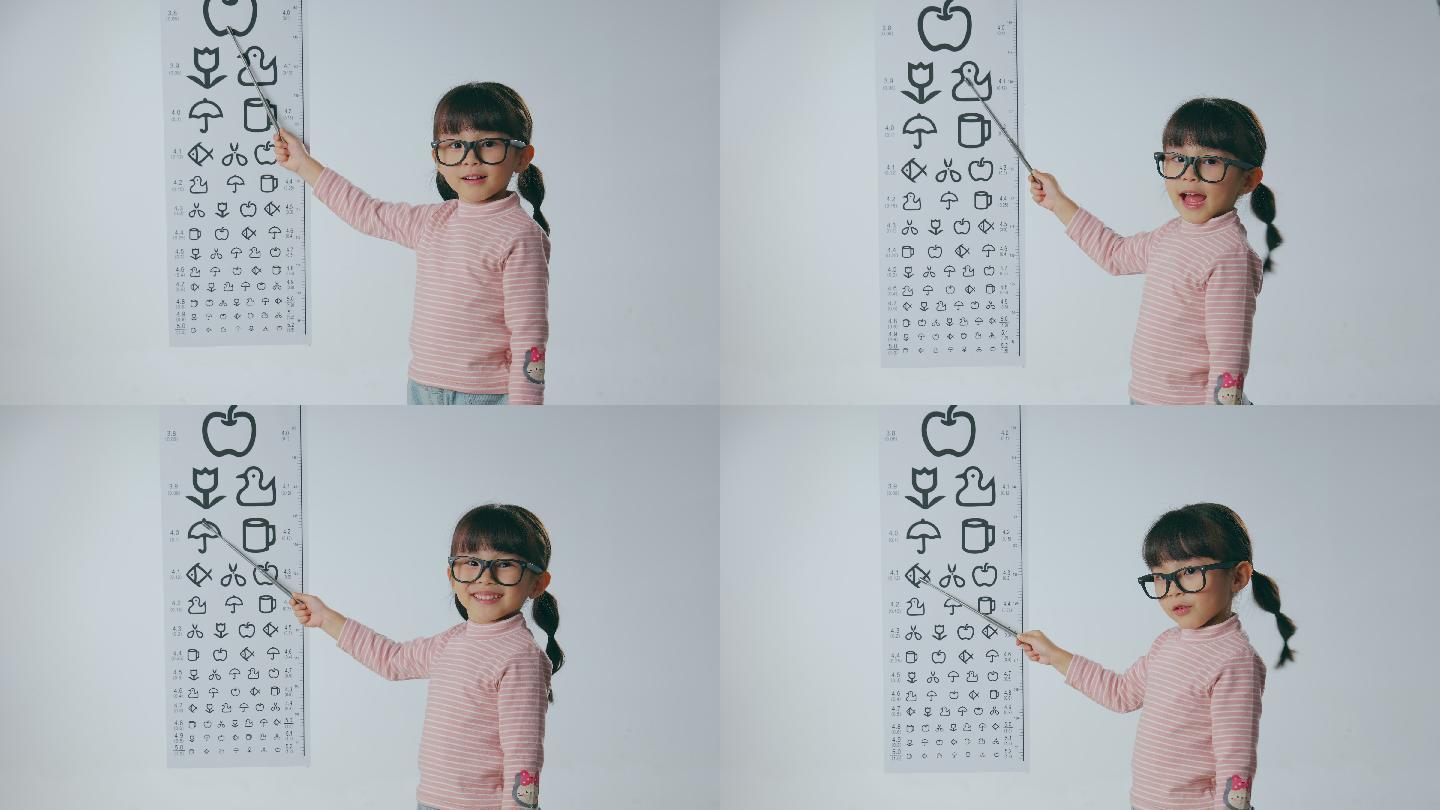 视力表旁的小女孩拿着指示棒