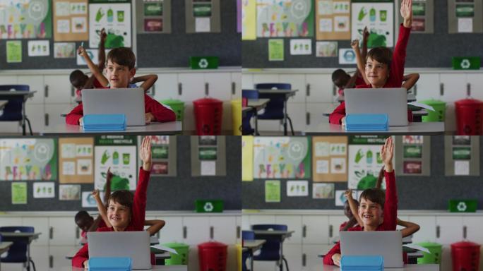快乐的白人学生肖像与笔记本电脑坐着举起手回答问题