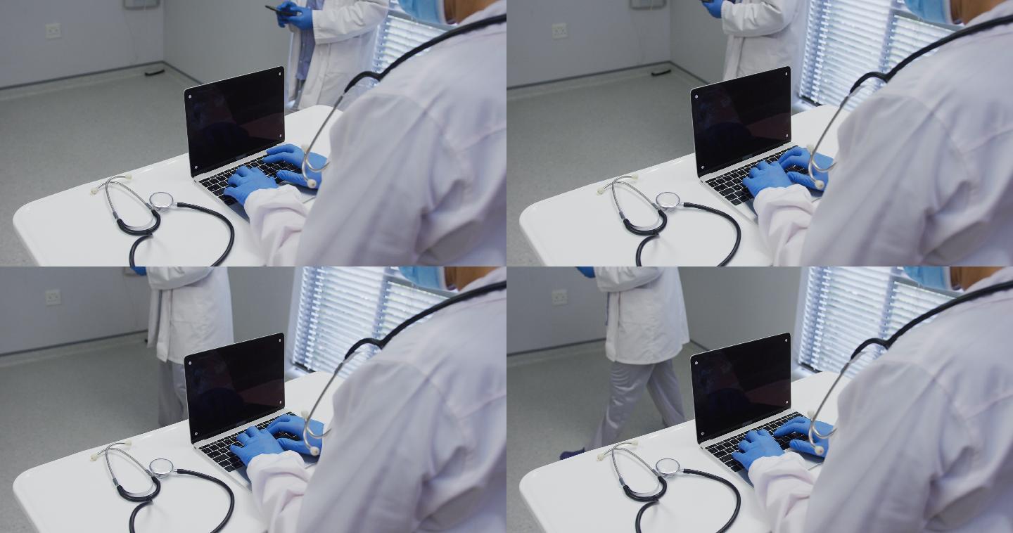 上腹部的医生戴着口罩和外科手套使用笔记本电脑，在屏幕上复制空间