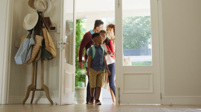 快乐的非裔美国家庭从前门进入房子