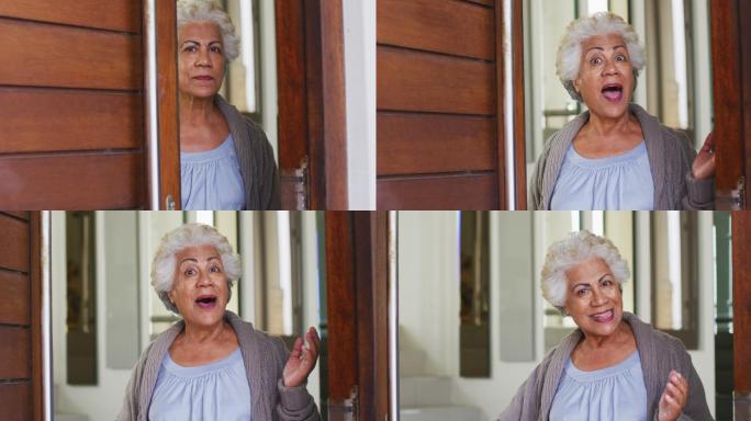 非裔美国老年妇女打开前门欢迎回家的画像