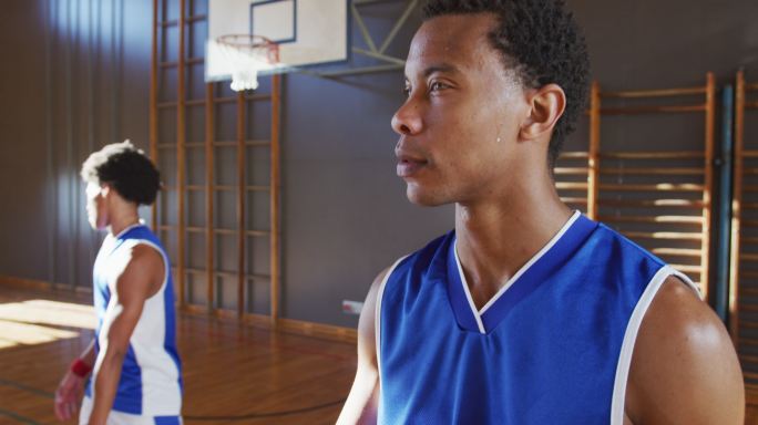 非裔美国男子篮球运动员的肖像和队友在背景中