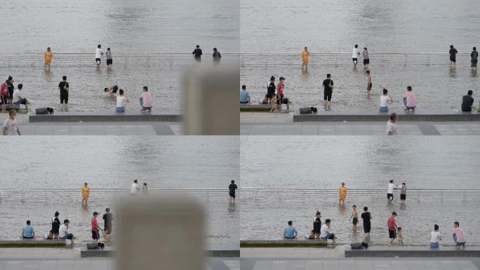 夏天消暑纳凉水边江滩边上玩水的人群