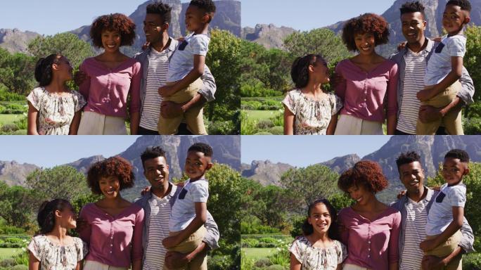 快乐的非裔美国父母的肖像，女儿和儿子站在户外