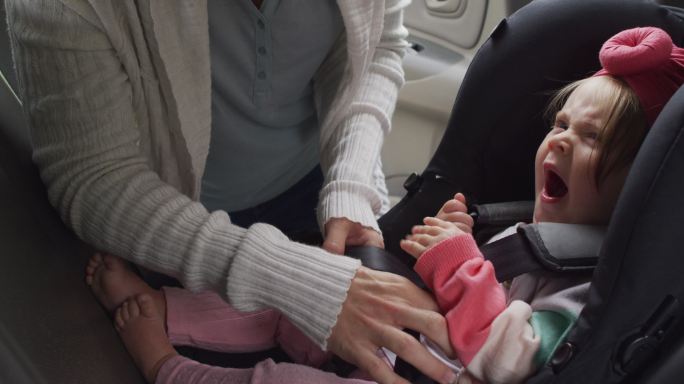 白人母亲把孩子放在车里的安全座椅上