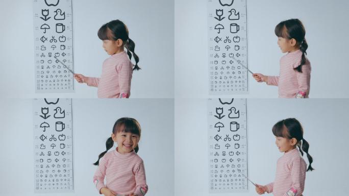 视力表旁的小女孩拿着指示棒