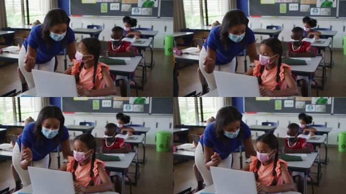 不同的女教师帮助女学生使用笔记本电脑，都戴着口罩